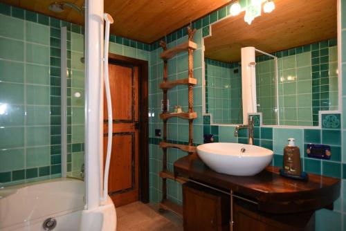 a bathroom with a sink and a tub and a mirror at Splendida villa in riva al mare in Orosei