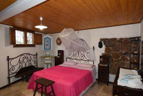 a bedroom with a large bed with a red blanket at Splendida villa in riva al mare in Orosei