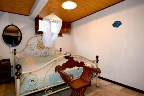 1 dormitorio con cama, espejo y silla en Splendida villa in riva al mare, en Orosei