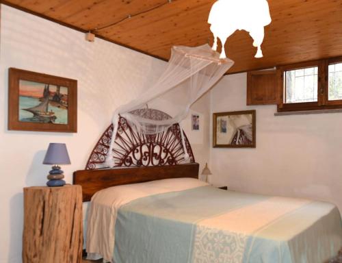 1 dormitorio con cama y lámpara de araña en Splendida villa in riva al mare, en Orosei