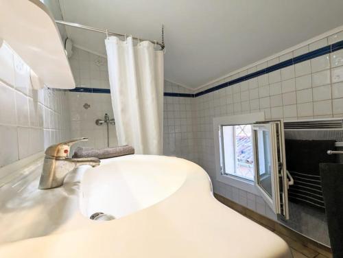 lavabo blanco en un baño con ventana en Plume, en LʼIsle-sur-la-Sorgue