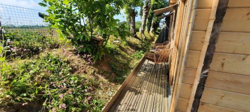 a porch of a house with a fence and flowers at Chalet Studio 5kms Etretat in Villainville