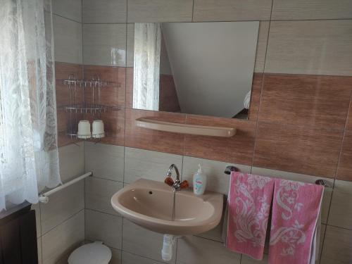 a bathroom with a sink and a mirror and a toilet at Molnár Vendégház in Bük