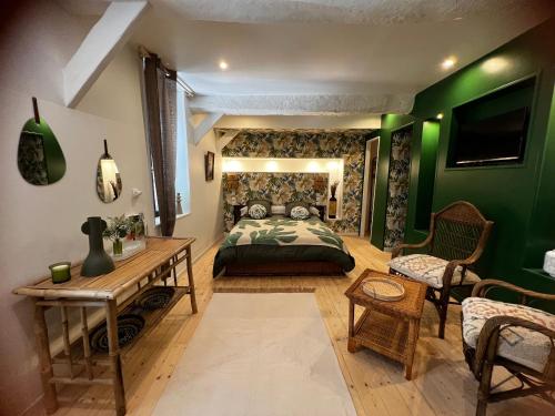 - une chambre dotée d'un lit avec un mur vert dans l'établissement Le Cèdre 1830 Maison d'hôtes de charme et spa, à Saint-Féliu-dʼAvall