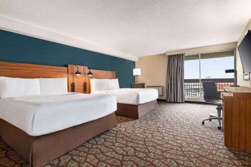 a hotel room with two beds and a balcony at Wyndham Garden Niagara Falls Fallsview in Niagara Falls