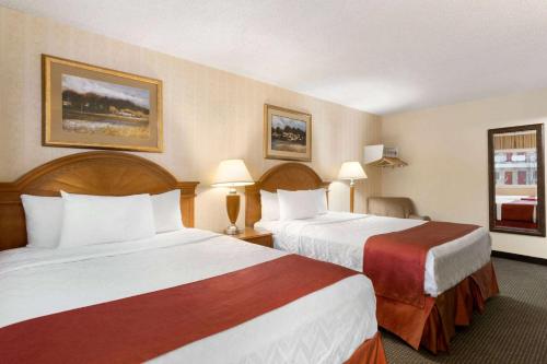 a hotel room with two beds and two lamps at Travelodge by Wyndham North Battleford in North Battleford