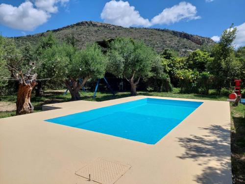 an empty swimming pool in front of a mountain at Sofiana Traditional Villa with swimming pool in Drapaniás
