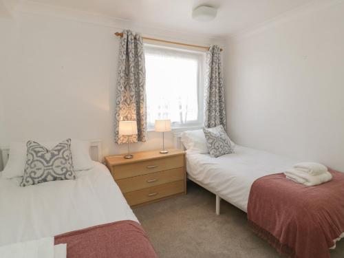 a bedroom with two beds and a window at 25 South Snowdon Wharf in Porthmadog
