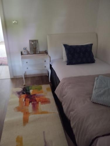 a bedroom with two beds and a dresser and a rug at Apartman All seasons in Sarajevo