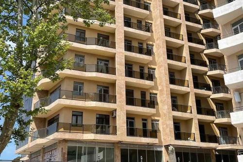 a large apartment building with balconies and a tree at Europalace Gonio in Gonio