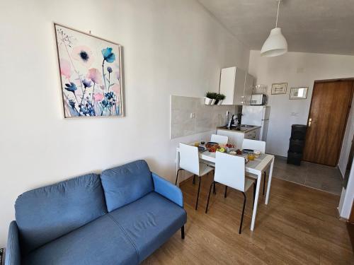 a living room with a blue couch and a table at Studio apartment PEGY in Vir