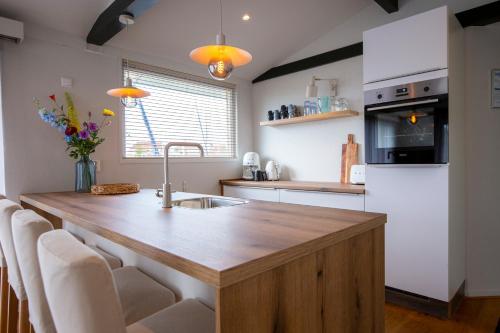 a kitchen with a large wooden island in a kitchen at Unieke woonboot in Harlingen in Harlingen