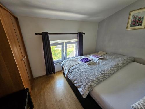 a small bedroom with a bed and a window at Studio apartment PEGY in Vir