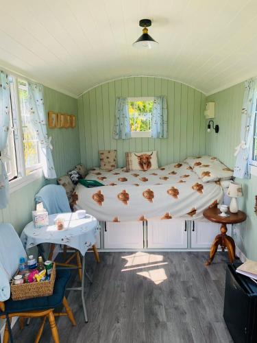 a bedroom with a large bed in a room at Bells Meadow Shepherds Hut in Kings Lynn