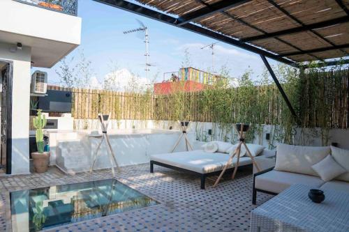 un patio con sofá, mesa y piscina en Riad Zhor Tanger - Médina en Tánger