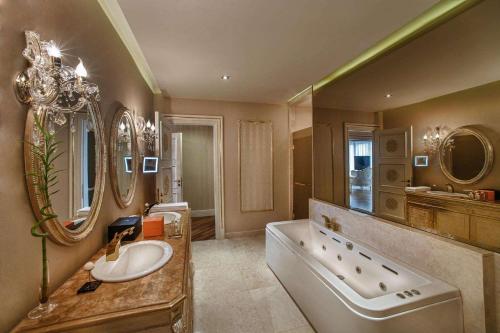 a large bathroom with a tub and a sink and a tub at Maxx Royal Belek Golf Resort in Belek
