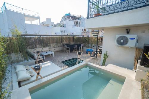 a small swimming pool with chairs and a table at Riad Zhor Tanger - Médina in Tangier