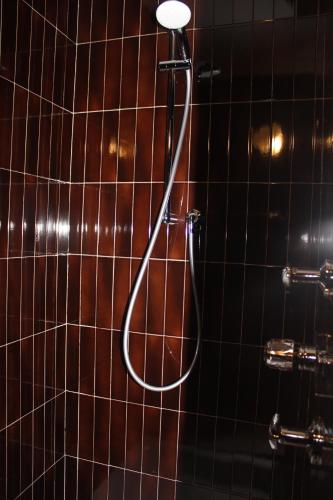 una ducha con cabezal de ducha en una pared de azulejos en B&B Kehrerhof, en Rifiano