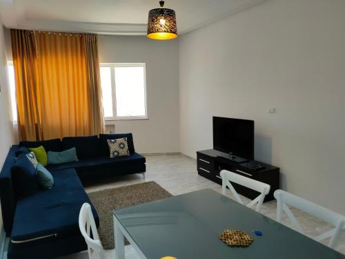 - un salon avec un canapé bleu et une table dans l'établissement luxury family apartment in ain Zaghouan nord, à El Aouina