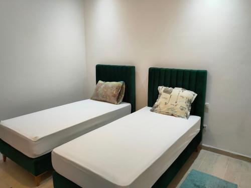 two beds sitting next to each other in a room at luxury family apartment in ain Zaghouan nord in El Aouina
