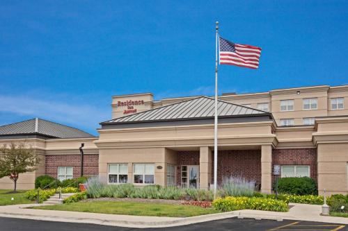 a building with an american flag in front of it at Residence Inn by Marriott Chicago Naperville/Warrenville in Warrenville