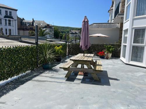 a picnic table and an umbrella on a patio at Beautiful Apartment,no 1, With Parking in Ilfracombe