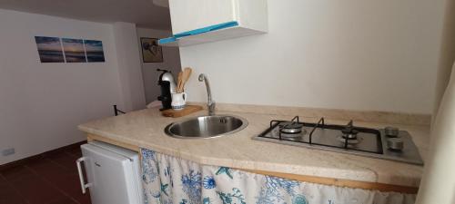 a kitchen counter with a sink and a stove at Casa Sartiglia in Oristano