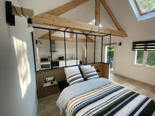 a bedroom with a large bed with a large mirror at Gîtes L'Ancienne Ecurie - L'Ancien Atelier in Saint-Quentin-en-Tourmont