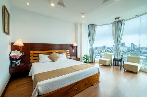 a bedroom with a bed and a view of a city at Adina 3 Star Hotel in Danang
