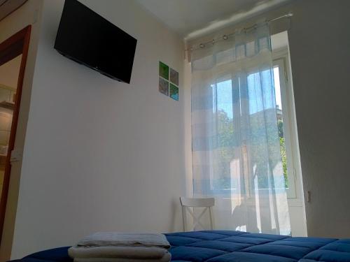 - une chambre avec un lit et une télévision murale dans l'établissement Affittacamere DA MARIA TERESA, à Sestri Levante
