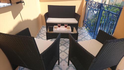 a balcony with two chairs and a table with two drinks at Christos Katerina House in Pythagoreio