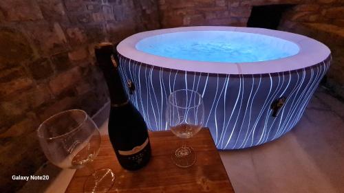 a hot tub with a bottle of wine and two glasses at HIŠA KAPIŠ with HOT TUBE in Koper