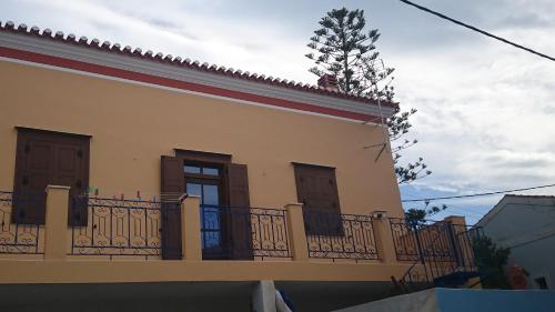 a yellow house with a balcony with a fence at Christos Katerina House in Pythagoreio