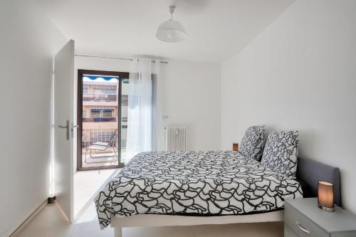 a white bedroom with a bed and a window at LE BALZAC T3 centre ville proche toutes commodités in Antibes