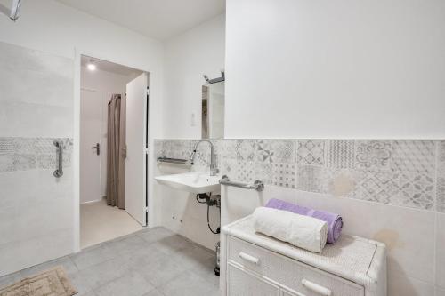 a white bathroom with a sink and a shower at LE BALZAC T3 centre ville proche toutes commodités in Antibes