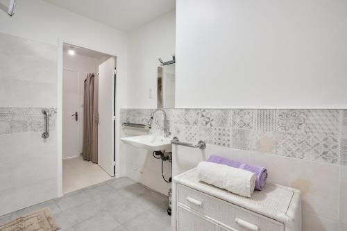 une salle de bain blanche avec un lavabo et une douche dans l'établissement LE BALZAC T3 centre ville proche toutes commodités, à Antibes