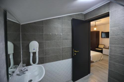 a bathroom with a sink and a room with a bed at Casa Izabela in Năvodari
