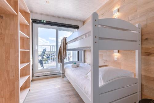 a bedroom with a bunk bed and a large window at Magnificent Apartment with Great Panoramic Seaview in De Haan