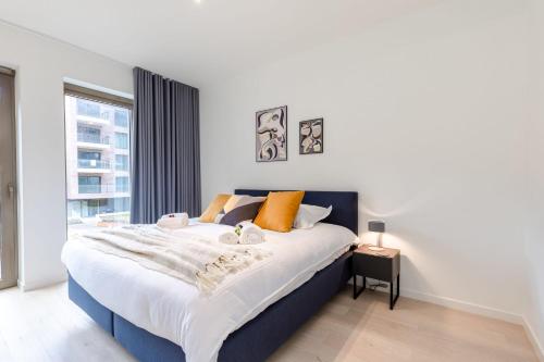 um quarto com uma cama grande e uma janela em Brand new holiday home with high-end finishing and private parking space, at a stone's throw from the beach em Ostend