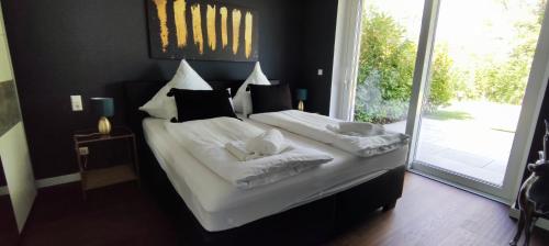 a bedroom with a bed with white sheets and pillows at Quartier4 in Sonthofen