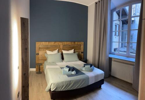 a bedroom with a bed with a large window at Creton apartment -La casa nel cuore della città- CIR 0121 in Aosta