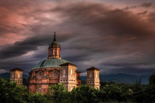 a building with a green roof on top of trees at L'antica Fornace di Barale Emanuela in Vicoforte