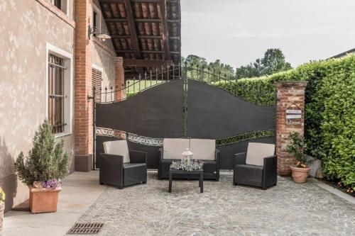a patio with chairs and a table and a fence at L'antica Fornace di Barale Emanuela in Vicoforte