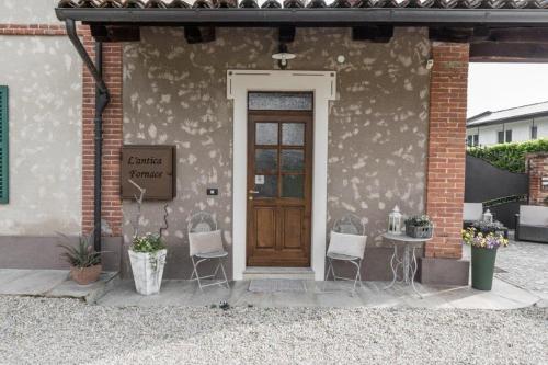a house with a door and a table and chairs at L'antica Fornace di Barale Emanuela in Vicoforte
