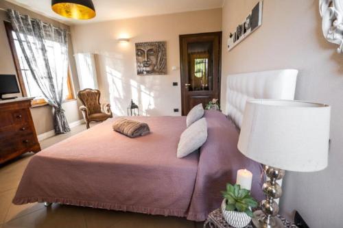 a bedroom with a purple bed and a lamp at L'antica Fornace di Barale Emanuela in Vicoforte