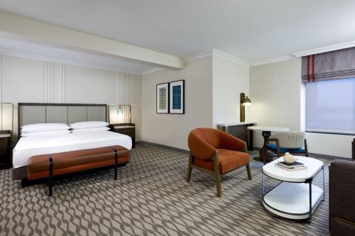 a hotel room with a bed and a chair and a table at JW Marriott Houston by the Galleria in Houston