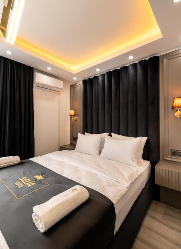 a bedroom with a large bed with a black headboard at Selia SUİTES in Trabzon