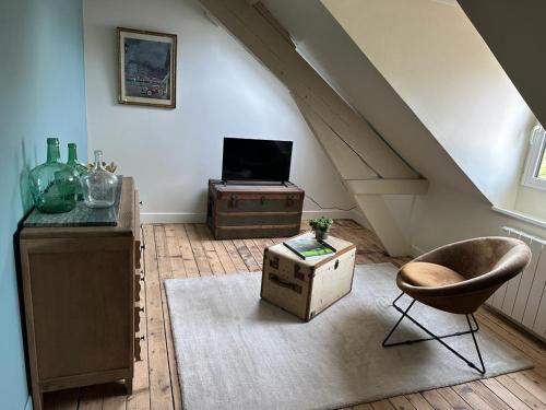 a living room with a staircase with a chair and a table at La maison du tripot in Honfleur