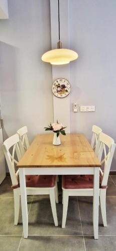 a dining room table with white chairs and a light fixture at Malaga Lodge Apartments in Málaga