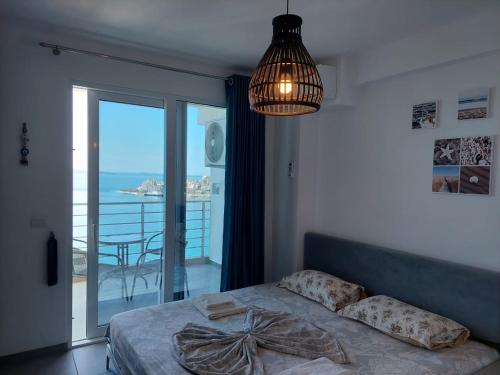 een slaapkamer met een bed en uitzicht op de oceaan bij Mihaly Apartment in Sarandë